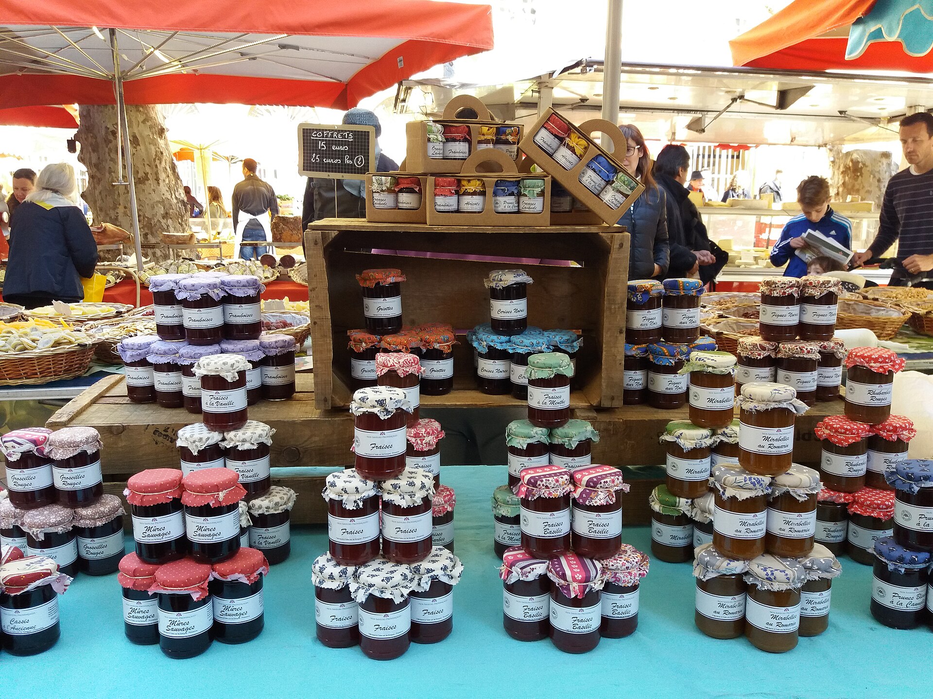 Pots de confiture alignés sur un étal de marché, étiquettes manuscrites